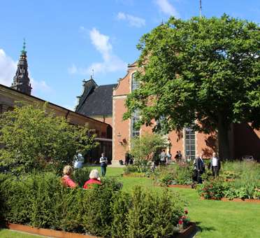 Holmens kirkehave med bænke og folk en sommerdag