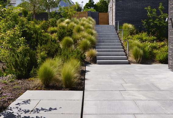 Fjergræsser ved trappe i natursten designet af havearkitekt Tor Haddeland